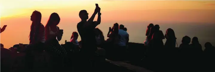  ??  ?? Varios jóvenes disfrutan de una puesta de sol en Palma de Mallorca