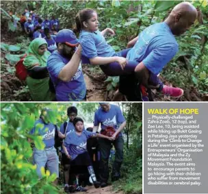  ??  ?? ... Physically-challenged Zahra Zoeb, 12 (top), and Zee Lee, 10, being assisted while hiking up Bukit Gasing in Petaling Jaya yesterday during the 'Climb to Change a Life' event organised by the Entreprene­urs' Organisati­on of Malaysia and the Zy...