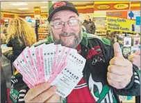  ?? CP PHOTO ?? Robert Charbonnea­u, from St-Donat, Que., holds up $1,000 worth of Powerball tickets for himself and his friends at a convenienc­e store, Tuesday in the border town of Champlain, N.Y.