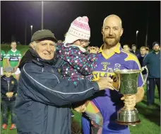 ??  ?? Jackie Napier presents Carnew captain Diarmuid Doran, with daughter Aoibhe, with the JBHC cup.