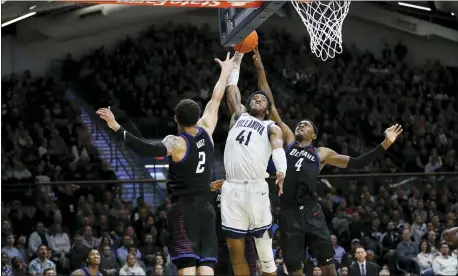  ?? MATT SLOCUM — THE ASSOCIATED PRESS ?? Villanova’s Saddiq Bey, centrer, tries to get a dunk past DePaul’s Paul Reed (4) and Jaylen Butz (2) during the second half Tuesday. Bey helped lead the Wildcats to a 79-75win in overtime.