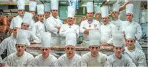  ??  ?? French chef Olivier Cauvin, (5thL), alongside chef Paul Bocuse (C), Sergio Remolina, (3rdR) from the Culinary Institute of America poses in l’Aubergede Pont de Collonges kitchen, during a culinary work shop, on November 09, 2012, in...