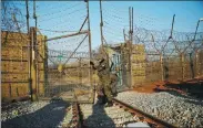  ?? KIM HONG-JI / REUTERS ?? ROK soldiers open the gate as the railway which leads to the DPRK is seen, inside the demilitari­zed zone in Paju, Republic of Korea, on Friday.