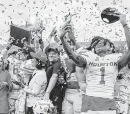  ?? Butch Dill / Associated Press ?? Houston wide receiver Nathaniel Dell celebrates with his teammates after beating Auburn in the Birmingham Bowl to cap a 12-2 season for the Cougars.