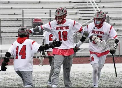  ?? DREW ELLIS — MEDIANEWS GROUP ?? Troy Athens’ Aidan Burchi, middle, celebrates a goal with teammate Jake Holter, left, and another teammate during Tuesday’s 16-9victory over crosstown rival Troy at Athens High School. The Red Hawks evened their season record at 2-2. Troy saw its record fall to 2-3.