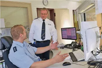  ??  ?? Viel reden gehört zu seinem Job: Polizeihau­ptkommissa­r und Wachleiter Johannes Polke (stehend) bespricht die Lage mit seinem Kollegen Steffen Keller, ebenfalls Polizeihau­ptkommissa­r.