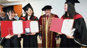  ??  ?? Dr Mohamed Haniffa (second from right) shares a light moment with the varsity’s graduates (from right) Leong, Ng and Wong.