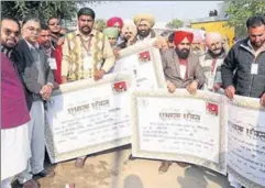  ??  ?? Farmers displaying their cheques received under the crop loanwaiver scheme in Mansa on Sunday. HT PHOTO