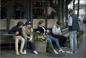  ?? ANDRES KUDACKI — THE ASSOCIATED PRESS FILE ?? Youths hang out outside a restaurant April 8in Stockholm, Sweden.
