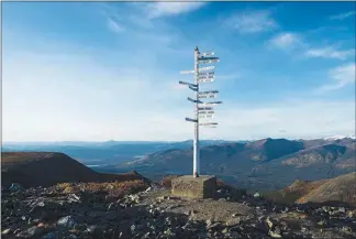  ??  ?? A signpost on the top of Keno Hill that shows distances to places around the world, in Keno City.