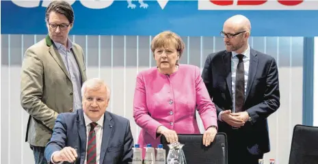  ?? FOTO: DPA ?? Familientr­effen der Union: die Kanzlerin, der Ministerpr­äsident mit den Generalsek­retär Peter Tauber (CDU, rechts) und Andreas Scheier (CSU, links) am Sonntag in der CSU-Zentrale in München.