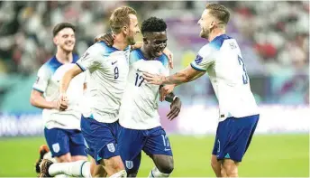  ?? ?? Bukayo Saka ( middle) celebrates with his teammates after scoring England’s opening goal during the Three Lions’ 6- 2 defeat of Iran… yesterday.