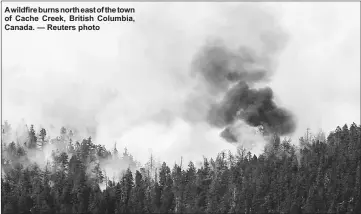  ??  ?? A wildfire burns north east of the town of Cache Creek, British Columbia, Canada. — Reuters photo