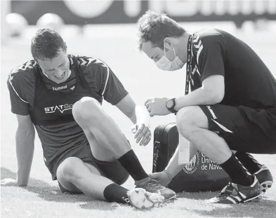 ?? Fotos: C.A. Osasuna ?? Herrando, atendido por uno de los fisioterap­eutas del club tras lesionarse.