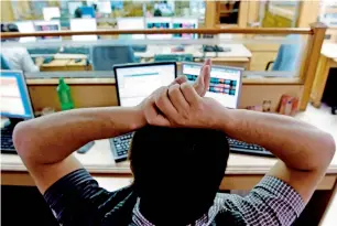  ?? — AFP ?? A stock dealer watches share prices on his screen at a brokerage house in Mumbai.