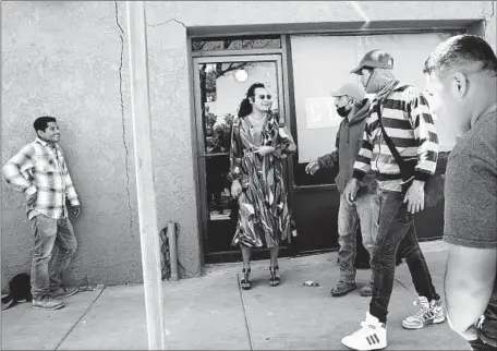  ?? Photograph­s by Dania Maxwell Los Angeles Times ?? CALEXICO MAYOR Raúl Ureña, center, chats with farmworker­s after they teased him from across the street for wearing a dress.