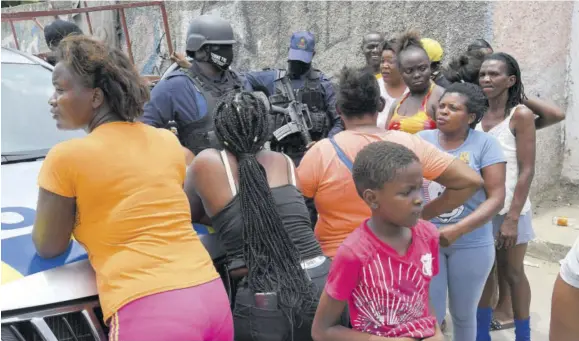  ??  ?? Residents of Seivwright Gardens, St Andrew, in discussion with police on York Avenue after tempers cooled following a fiery protest against the killing of a man in the community by cops in this June 6, 2020 file photo.