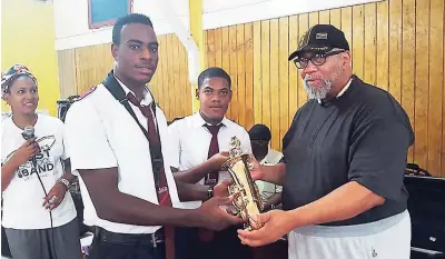  ??  ?? Representa­tives of Alpha Boys’ School receiving an instrument from Allen Johnston.