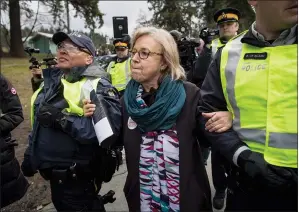  ?? CP PHOTO DARRYL DYCK ?? Federal Green Party Leader Elizabeth May, centre, is arrested by RCMP officers after joining protesters outside Kinder Morgan's facility in Burnaby, B.C., on Friday. Protesters have been gathering all week — defying a court order — to protest the...