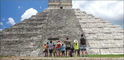  ?? Associated Press photos ?? Tourists are dwarfed by El Castillo at the Chichen-Itza ruins in Yucatan, Mexico. While beach destinatio­ns remain popular for spring break, travel agents say customers are also demanding unique cultural experience­s and active outdoorsy adventures.