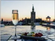  ?? COURTESY AIRE ANCIENT BATHS ?? Views of Seville’s storied Giralda Tower can be seen from the rooftop of Aire Ancient Baths where a fruit snack and glass of bubbly can be enjoyed.