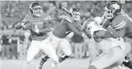  ?? TIM WARNER / GETTY ?? Former Houston quarterbac­k D’Eriq King looks to throw as right tackle Jarrid Williams blocks a Tulsa pass rusher. Both have transferre­d to the Hurricanes.