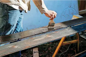  ?? [PHOTOS BY NATE BILLINGS, THE OKLAHOMAN] ?? Andy Zeeck applies oil to charred wood after demonstrat­ing shou sugi ban.