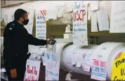  ?? ANNA MONEYMAKER — THE NEW YORK TIMES ?? A law enforcemen­t officer looks at thank-you notes left for the U.S. Capitol Police in the tunnel to the Cannon House Office Building in Washington on Tuesday.