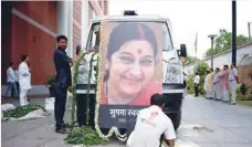  ?? — AFP ?? Workers decorate an ambulance with flowers and a picture of former foreign minister Sushma Swaraj at the Bharatiya Janata Party headquarte­rs in New Delhi on Wednesday.