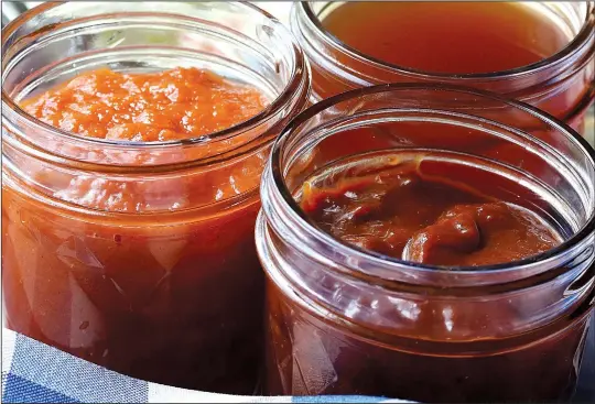  ?? St. Louis Post-Dispatch/TNS/HILLARY LEVIN ?? A selection of homemade barbecue sauces: clockwise from top, vinegary North Carolina-style Barbecue Sauce, thick and smooth Texas-style Barbecue Sauce and slightly textured Apple-Bourbon Barbecue Sauce.