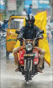  ??  ?? A motorist rides on a road during heavy rain in Chennai yesterday.