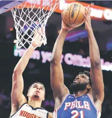  ?? — AFP photo ?? Embiid (right) shoots a lay up over Michael Porter Jr. of the Denver Nuggets during the second quarter at the Wells Fargo Centre in Philadelph­ia, Pennsylvan­ia.