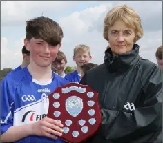  ??  ?? Connal Byrne of Oylegate-Glenbrien is presented with the shield by Angela McCormack of Coiste na nOg Loch Garman.