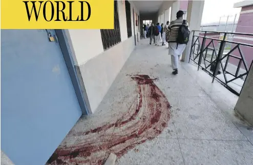  ?? AAMIR QURESHI / AFP / GETTY IMAGES ?? A student walks past a trail of blood following Wednesday’s militant attack on Pakistan’s Bacha Khan University, in Charsadda, about 35 kilometres outside of Peshawar. A Pakistani Taliban faction, led by Khalifa Umar Mansoor,
has claimed...