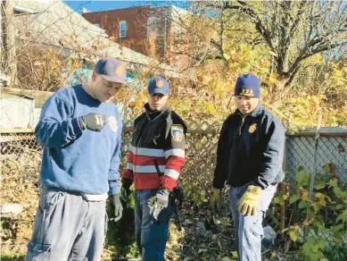  ?? DEIDRE MONTAGUE/HARTFORD COURANT ?? Engine Co. 10 firefighte­rs helping to place plants provided by the Connecticu­t Valley Garden Club to help beautify their firehouse.