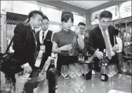  ?? XINHUA ?? Internatio­nal visitors to a wine expo taste local varieties of the heady beverage made in the Ningxia Hui Autonomous Region.