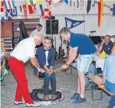 ?? FOTO: SCAW ?? Manuel Wolf baute in seine verblüffen­den Zaubertric­ks auch Mitglieder ein. Der Segelclub hatte fürs Jubiläum das Festzelt stilecht mit einer Flaggenpar­ade dekoriert.