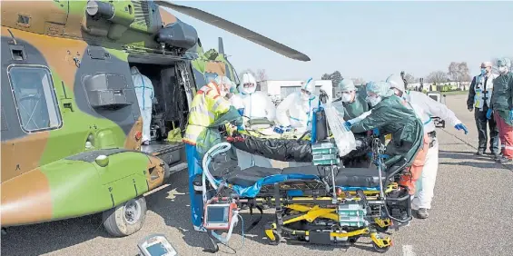  ?? EFE ?? Auxilio. Un grupo médico asiste a personas contagiada­s francesas en el aeropuerto alemán de Essen, donde serán hospitaliz­adas y tratadas.