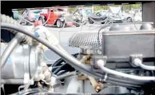  ??  ?? A line of cars can be seen through a window in Bella Vista resident Eric Gibby’s 1937 Chevrolet pickup’s engine bay, accented with a homemade spiderweb pattern. Gibby said he’s been driving the truck for about eight years after he spent five years building it.