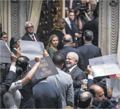  ?? Patricia de Melo Moreira / AFP ?? Diversos diputats portugueso­s exhibeixen cartells contra la visita del president brasiler, Lula da Silva, ahir.