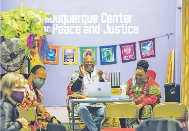  ?? PHOTOS BY JUAN ANTONIO LABRECHE/FOR THE NEW MEXICAN ?? Director Jim Harvey, left, and Tonya Covington, right, celebrate Saturday during the of Albuquerqu­e Center for Peace and Justice’s socially distanced Kwanzaa opening ceremony.