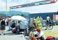  ??  ?? Marea gialla La lunghissim­a fila di camper in attesa, ieri mattina, di entrare nel circuito nel quale rimarranno fino a domenica sera Sopra, i tifosi con i vessilli gialli di Valentino Rossi all’ingresso della curva Palagio: per prendere i posti...