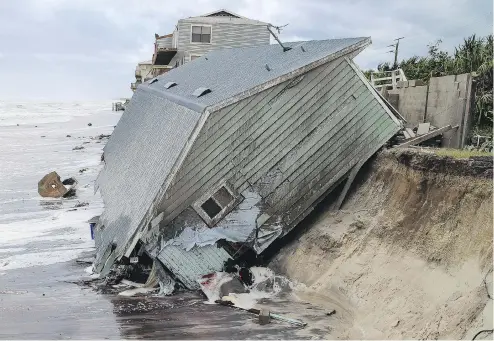  ??  ?? GARY LLOYD MCCULLOUGH / THE FLORIDA TIMES-UNION VIA THE ASSOCIATED PRESS A house slides into the Atlantic Ocean in the aftermath of hurricane Irma in Ponte Vedra Beach, Fla., on Monday.