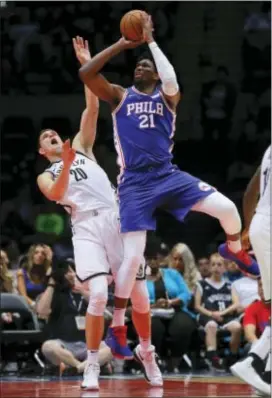  ?? JULIE JACOBSON — THE ASSOCIATED PRESS ?? Sixers center Joel Embiid (21) shoots next to Brooklyn’s Timofey Mozgov (20) during the third quarter Wednesday in Uniondale, N.Y.