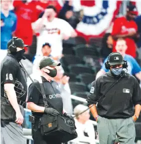  ?? AP PHOTO/JOHN BAZEMORE ?? Umpires review a play at the plate during the ninth inning of Sunday’s game between the Philadelph­ia Phillies and the Atlanta Braves in Atlanta.