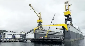  ?? THE CANADIAN PRESS FILES ?? A floating dry dock is seen at the Irving Shipyard in Halifax in 2013. The federal government says that three companies are participat­ing in a design competitio­n for new warships.