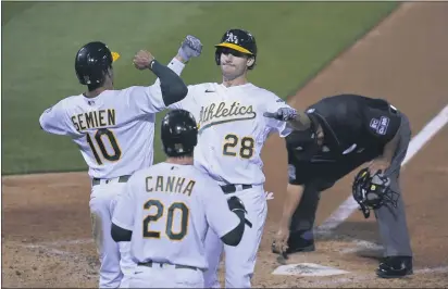  ?? PHOTOS BY ERIC RISBERG — THE ASSOCIATED PRESS ?? The A’s Matt Olson (28) is greeted by Marcus Semien (10) and Mark Canha (20) after hitting a three-run home run off Giants starting pitcher Logan Webb during the third inning on Friday in Oakland.