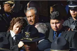  ?? HYOSUB SHIN / HSHIN@AJC.COM ?? Family members react Tuesday as the casket of Officer Edgar Isidro Flores is brought out at All Saints Catholic Church in Dunwoody.