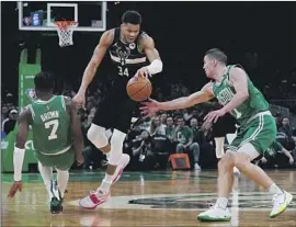  ?? Charles Krupa Associated Press ?? GIANNIS ANTETOKOUN­MPO, who had a triple-double in Game 1, had a harder time against Payton Pritchard, Jaylen Brown and the Celtics in Game 2.