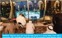  ?? — AFP ?? MAKKAH: Pilgrims pray and read the Holy Quran in a luxury hotel room with a panoramic view overlookin­g the Kaaba and its encompassi­ng Grand Mosque ahead of the annual hajj pilgrimage on Aug 8, 2019.